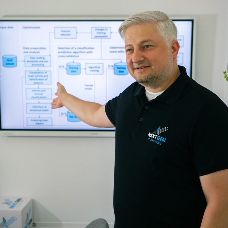 Mann zeigt auf ein Diagramm zur Prozessdarstellung an einem Bildschirm.