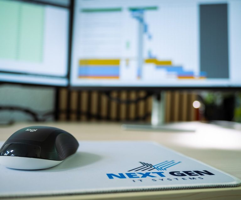 Besprechung mit einem lächelnden Mann und mehreren Personen an einem Tisch.